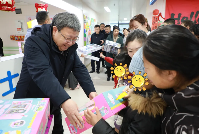 图为慰问儿童并送上开学礼包